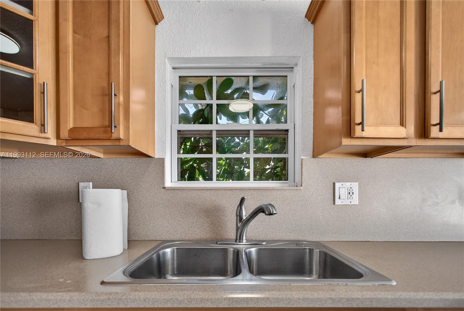 13471 Southwest 99th Terrace Miami, FL 33186 - Photo 38 of 44 a kitchen with a sink a window and cabinets