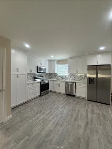 a view of a kitchen with a sink cabinets and stainless steel appliances