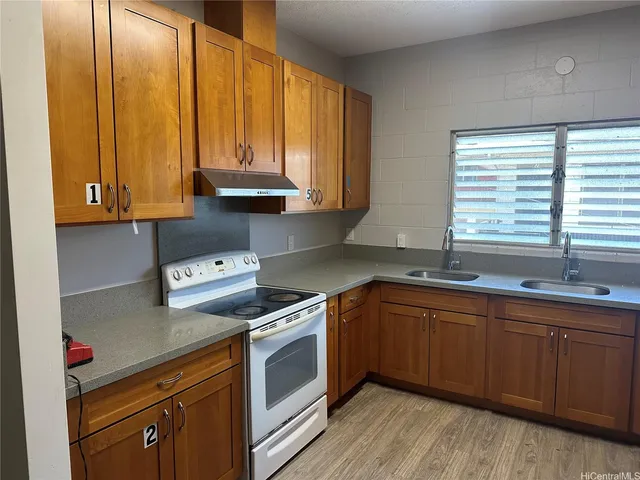a kitchen with stainless steel appliances granite countertop wooden cabinets a sink and dishwasher with wooden floor