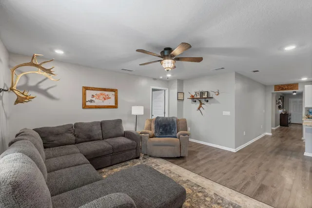 a living room with furniture and a wooden floor