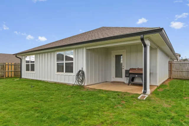 a backyard of a house with table and chairs