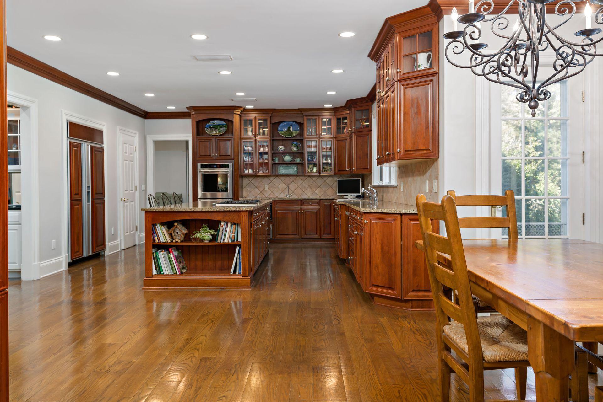 318 Ridgefield Road Wilton, CT 06897 - Photo 17 of 51 a kitchen with stainless steel appliances granite countertop a refrigerator a sink dishwasher a stove and a dining table with wooden floor