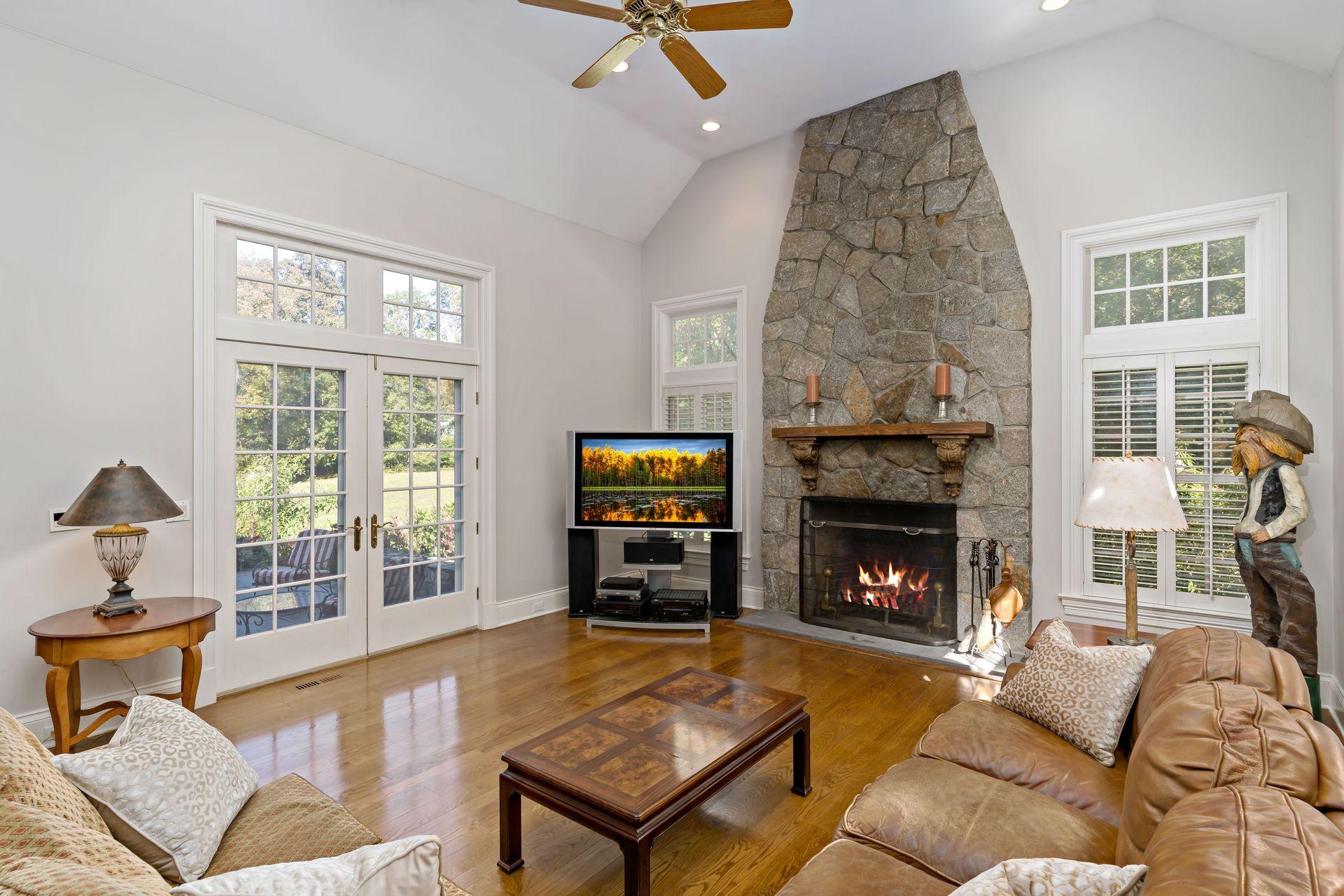 318 Ridgefield Road Wilton, CT 06897 - Photo 22 of 51 a living room with furniture a flat screen tv and a fireplace