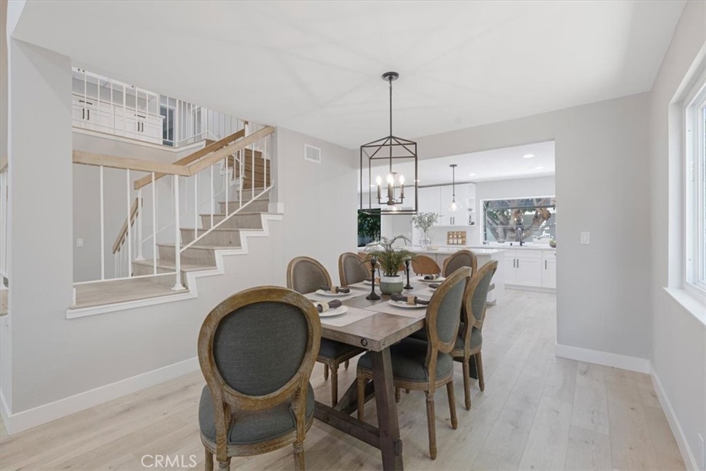 25032 Crystal Circle Lake Forest, CA 92630 - Photo 8 of 54 a dining room with furniture a chandelier and wooden floor