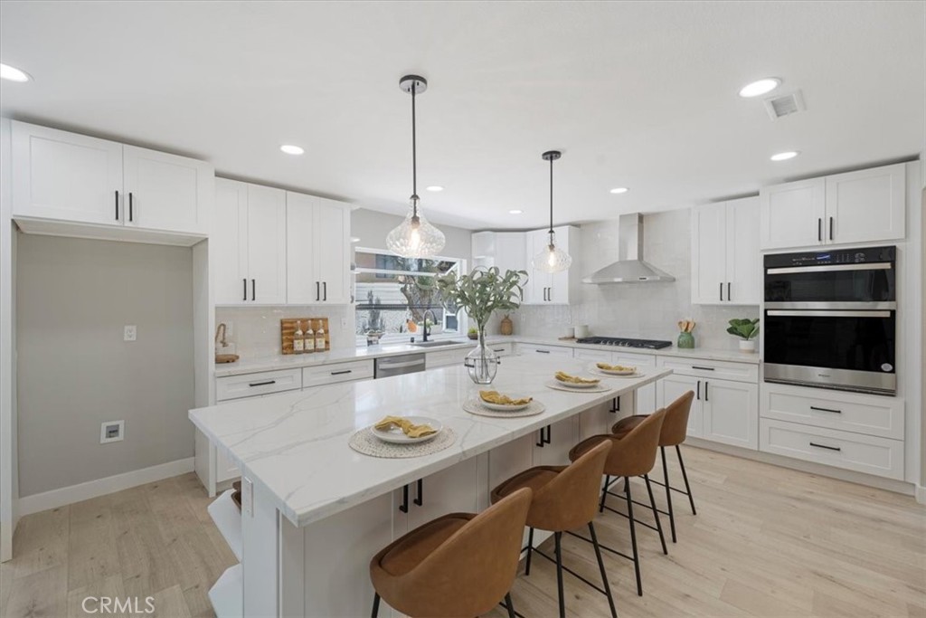 25032 Crystal Circle Lake Forest, CA 92630 - Photo 10 of 54 a kitchen with stainless steel appliances kitchen island a table and chairs in it