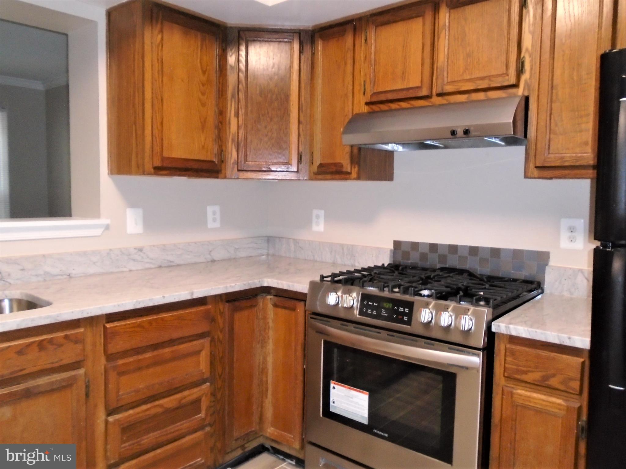 1914 Duffield Lane Alexandria, VA 22307 - Photo 3 of 50 a kitchen with wooden cabinets and a stove top oven