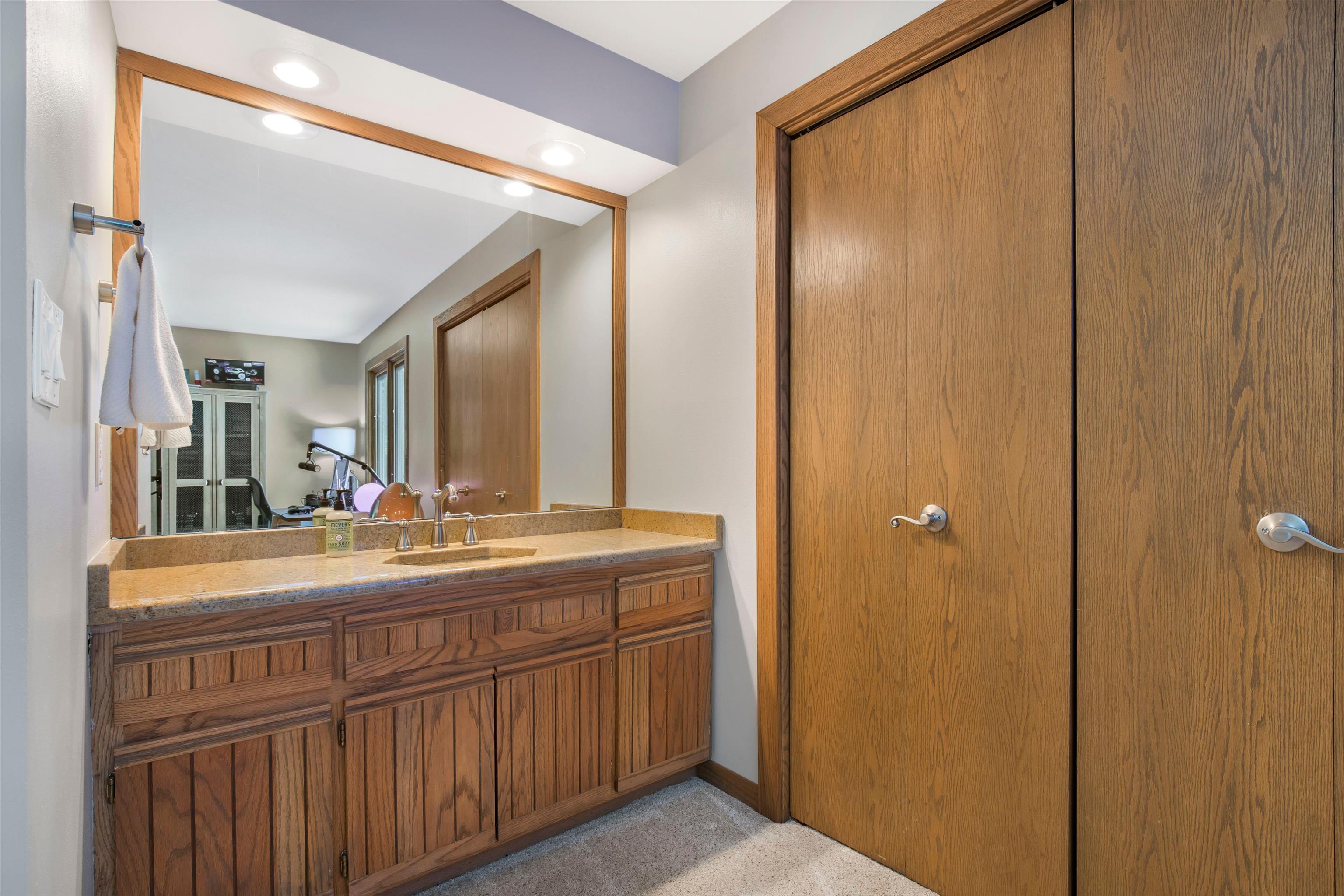 8024 Killarney Aire Road Roscoe, IL 61073 - Photo 20 of 45 a bathroom with a granite countertop sink and a mirror
