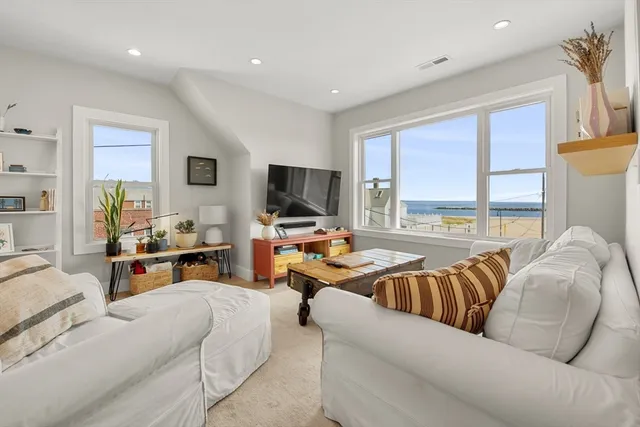 a living room with furniture flat screen tv and a large window