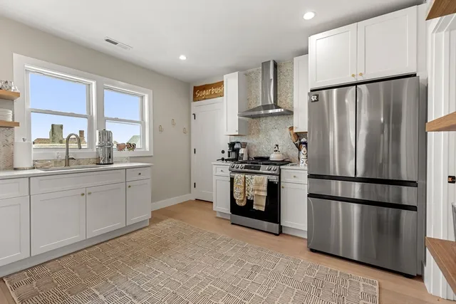 a kitchen with a refrigerator sink and cabinets