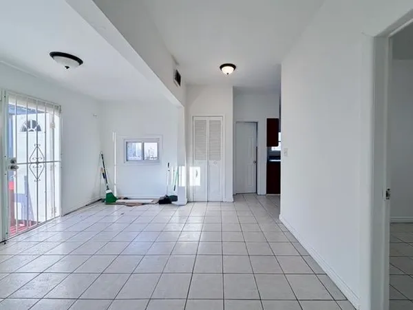 an empty room with entrance and windows