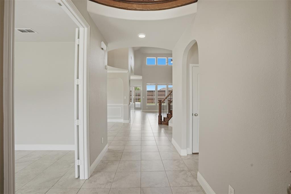 2217 Riviera Drive Little Elm, TX 75068 - Photo 13 of 36 Entryway featuring tiled flooring, arched doorways, a coffered ceiling element, and a staircase with wood banisters