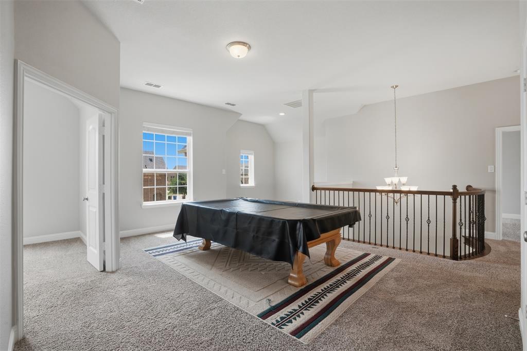 2217 Riviera Drive Little Elm, TX 75068 - Photo 26 of 36 Spacious carpeted bonus room featuring multiple windows, a curved staircase with wrought iron spindles, a neutral wall palette, and a flush mount ceiling light
