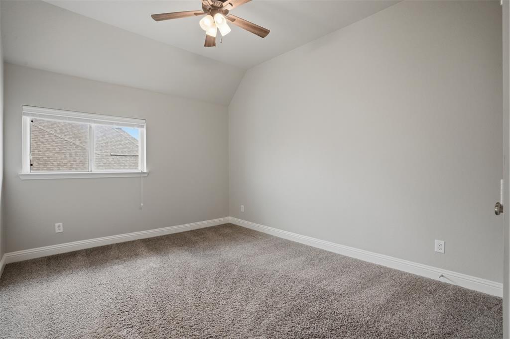 2217 Riviera Drive Little Elm, TX 75068 - Photo 29 of 36 Neutral-toned interior room with vaulted ceilings and a ceiling fan