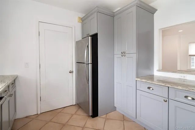 a view of cabinets with refrigerator in kitchen counter space and window