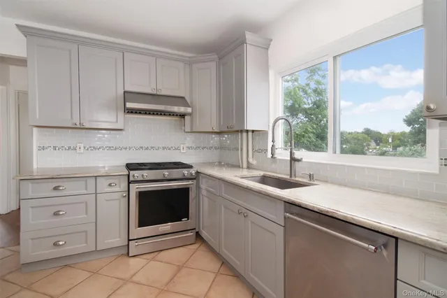 a kitchen with granite countertop a sink window and cabinets