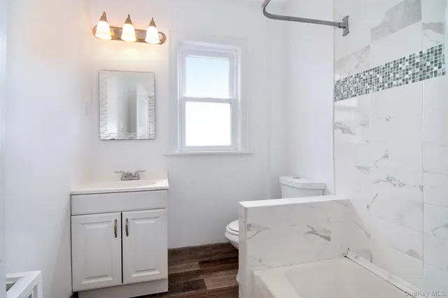 a bathroom with a sink mirror and a bathtub