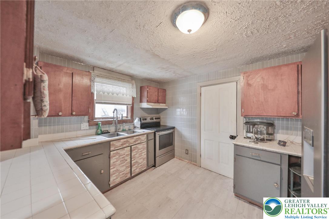 1291 Seidersville Road Bethlehem, PA 18015 - Photo 10 of 56 a kitchen with a sink stove and cabinets