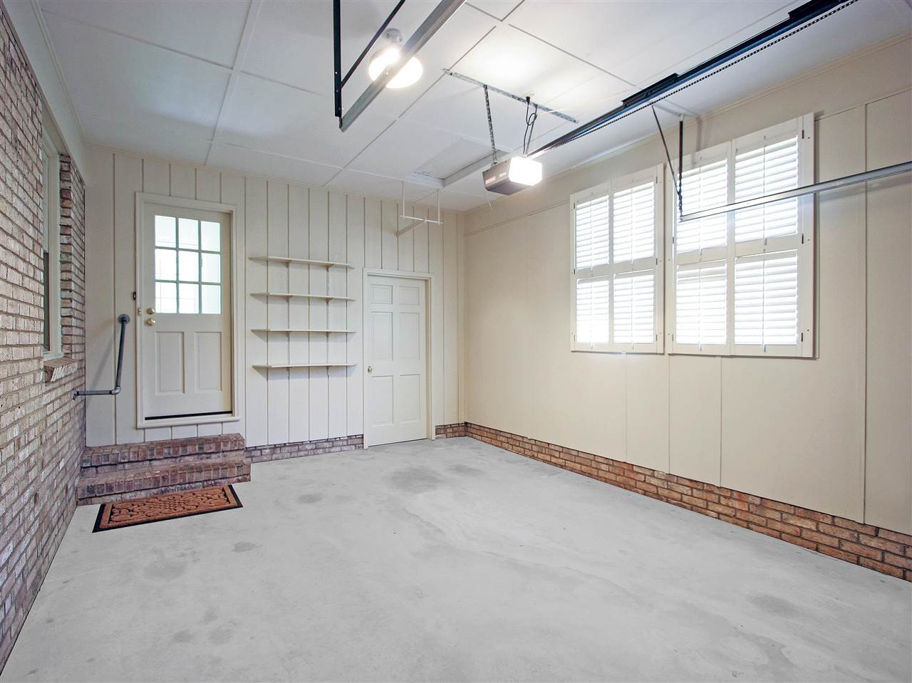1324 Kingston Ridge Road Cary, NC 27511 - Photo 23 of 30 Garage has new overhead door. Great spot for your car or maybe a workshop. Door at right in the photo leads to a nice-size storage room. Door at the left leads into the house. Double window with Planation shutters brings in natural light. Garage