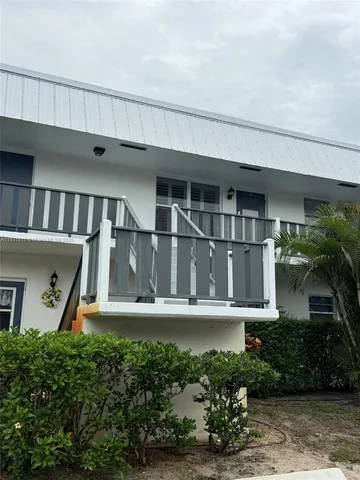 a kitchen with a white refrigerator sink and cabinets