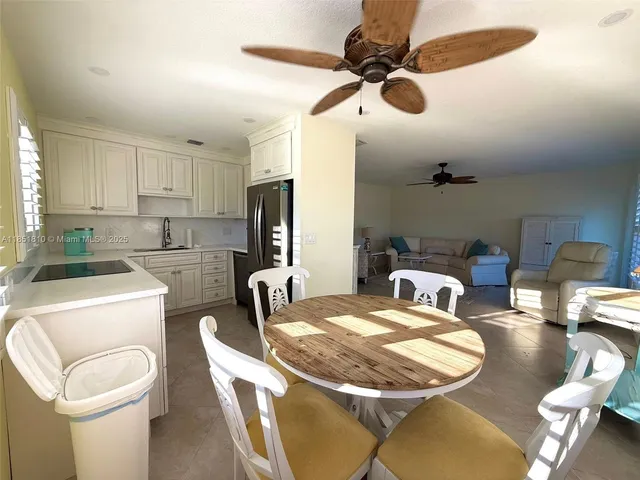 a kitchen with stainless steel appliances kitchen island granite countertop a refrigerator a sink a stove and island