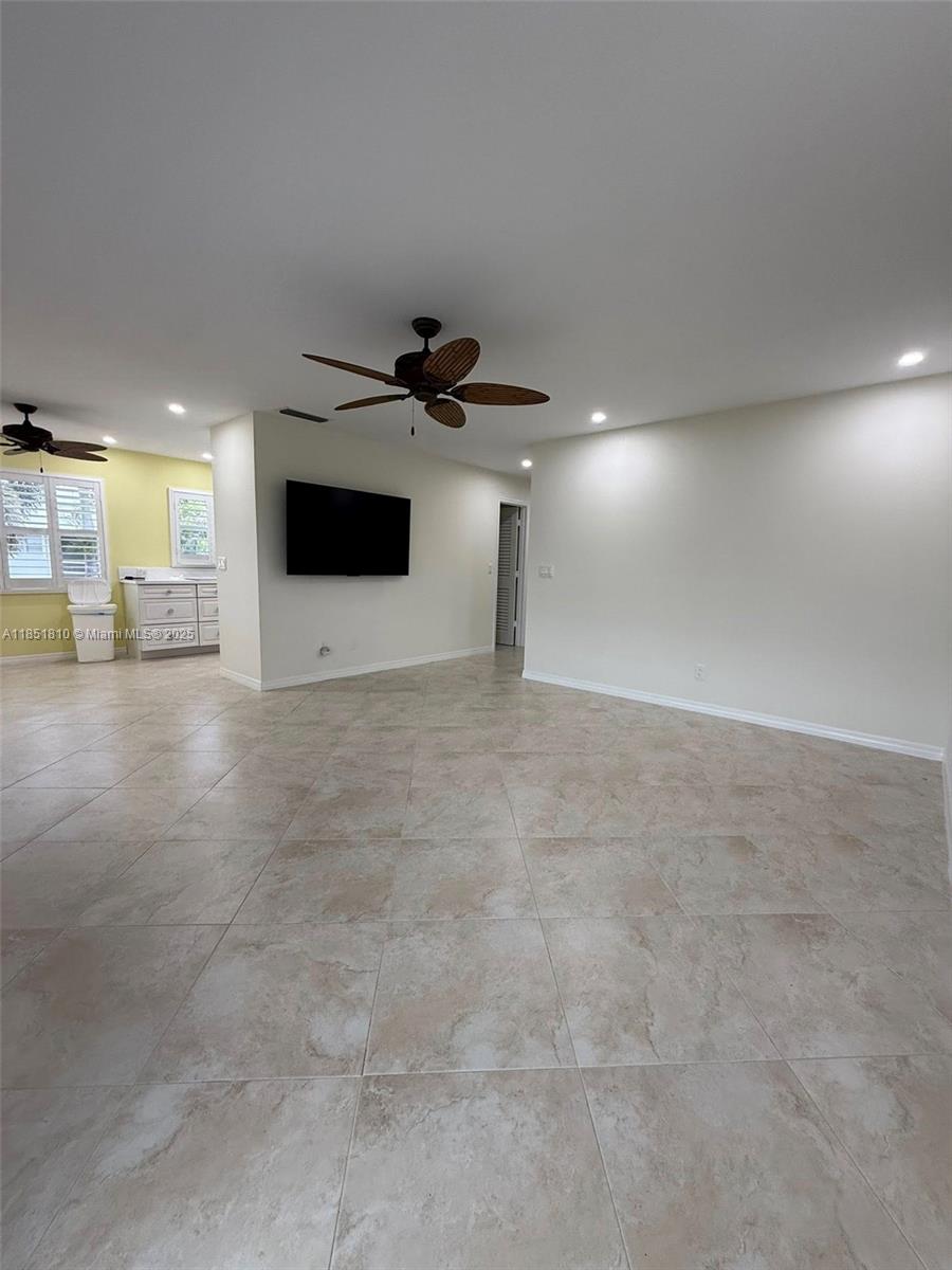 2929 Southeast Ocean Boulevard, Unit 14310 Stuart, FL 34996 - Photo 24 of 73 a view of a livingroom with a flat screen tv wooden floor and a ceiling fan