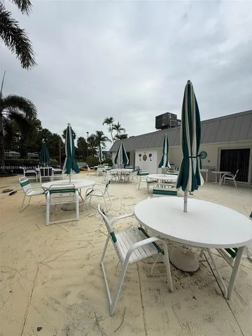 a kitchen with granite countertop a refrigerator sink stove and white cabinets