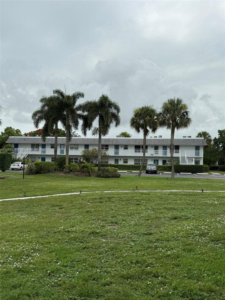 2929 Southeast Ocean Boulevard, Unit 14310 Stuart, FL 34996 - Photo 40 of 73 a view of a big building with a big yard and large trees