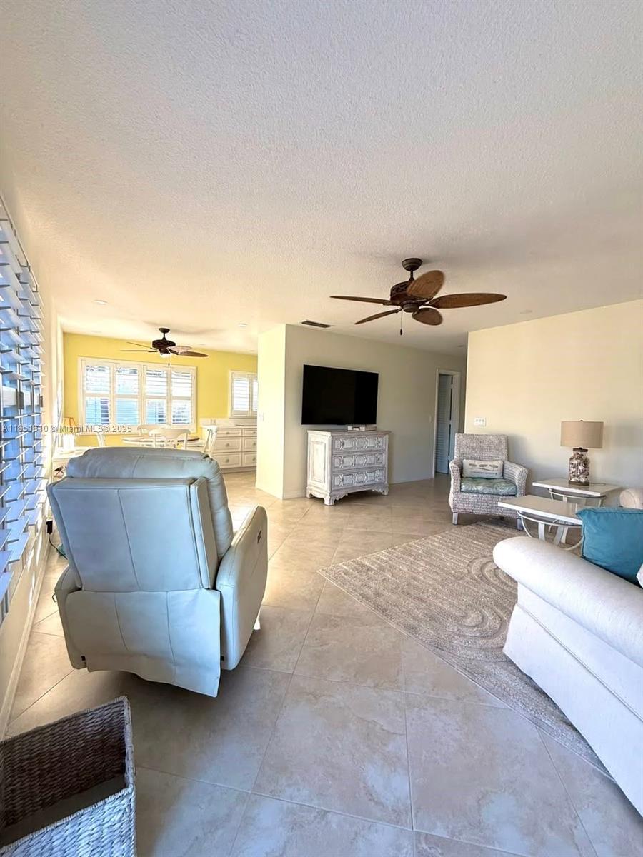 2929 Southeast Ocean Boulevard, Unit 14310 Stuart, FL 34996 - Photo 54 of 73 a living room with furniture and a flat screen tv