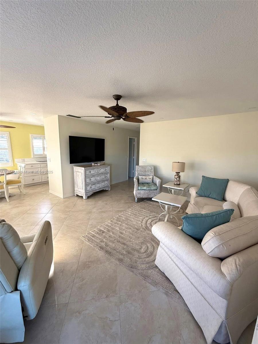2929 Southeast Ocean Boulevard, Unit 14310 Stuart, FL 34996 - Photo 59 of 73 a living room with furniture and a flat screen tv