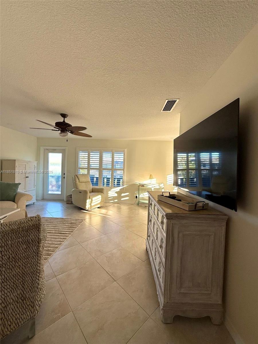 2929 Southeast Ocean Boulevard, Unit 14310 Stuart, FL 34996 - Photo 61 of 73 a living room with furniture and a flat screen tv