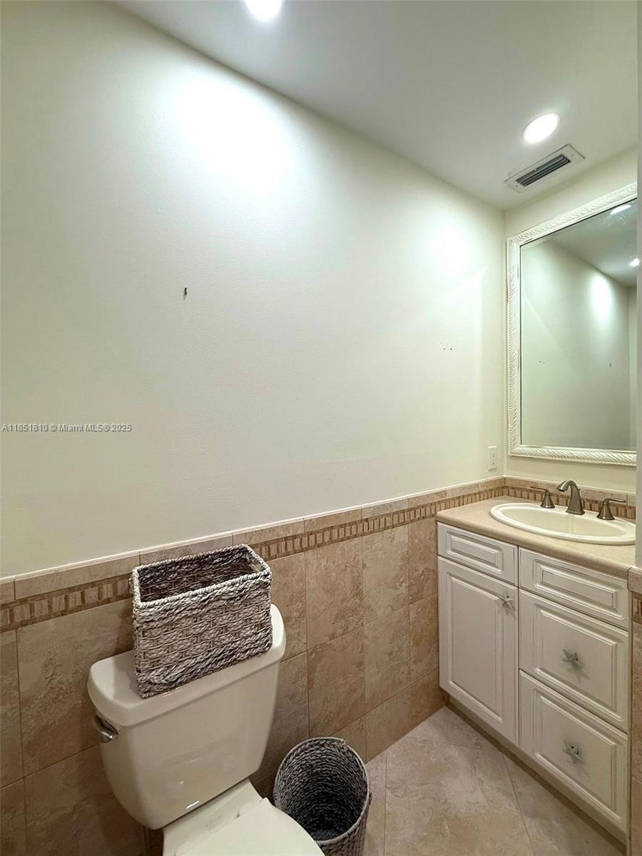 2929 Southeast Ocean Boulevard, Unit 14310 Stuart, FL 34996 - Photo 62 of 73 a bathroom with a toilet a sink and mirror
