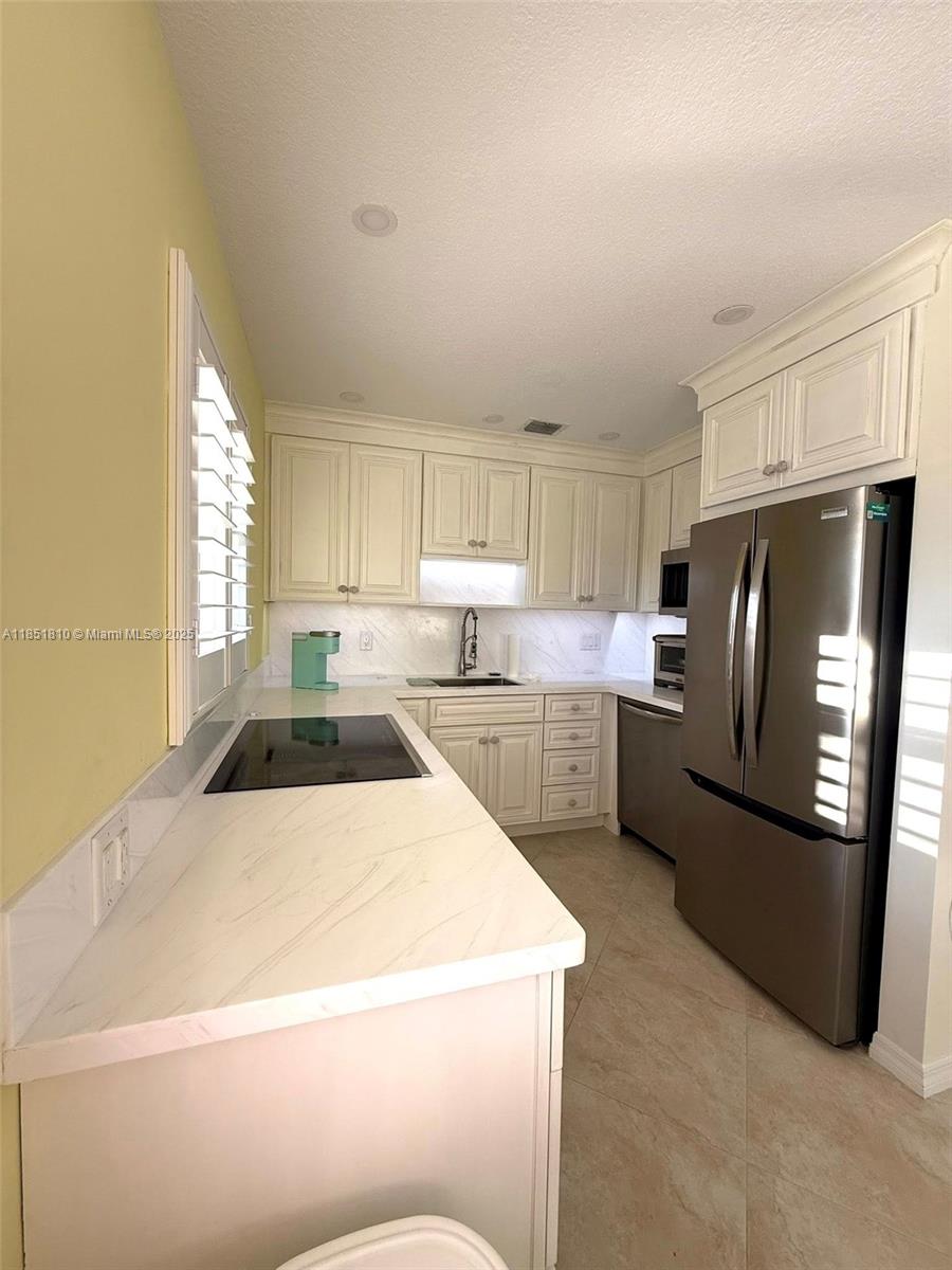 2929 Southeast Ocean Boulevard, Unit 14310 Stuart, FL 34996 - Photo 66 of 73 a kitchen with a refrigerator a stove a sink and a cabinets
