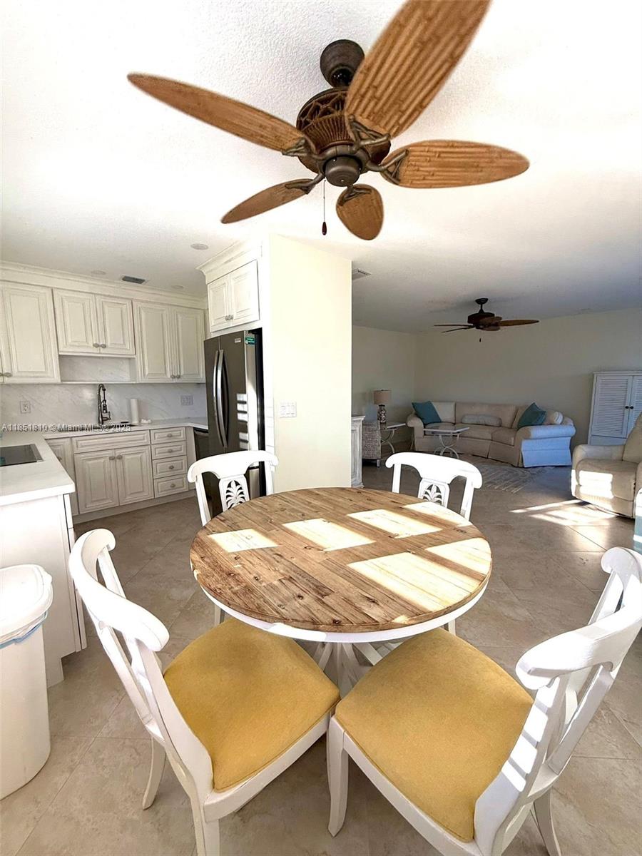 2929 Southeast Ocean Boulevard, Unit 14310 Stuart, FL 34996 - Photo 67 of 73 a kitchen with a table chairs and a stove