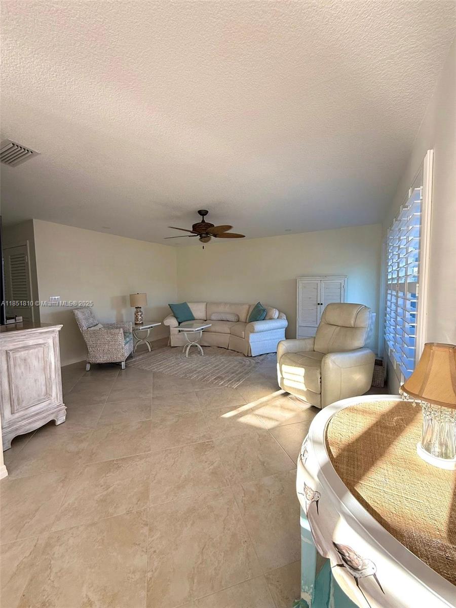 2929 Southeast Ocean Boulevard, Unit 14310 Stuart, FL 34996 - Photo 70 of 73 a living room with furniture and a lamp