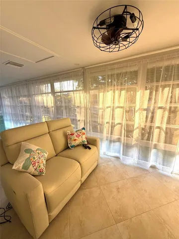 a living room with furniture and a floor to ceiling window