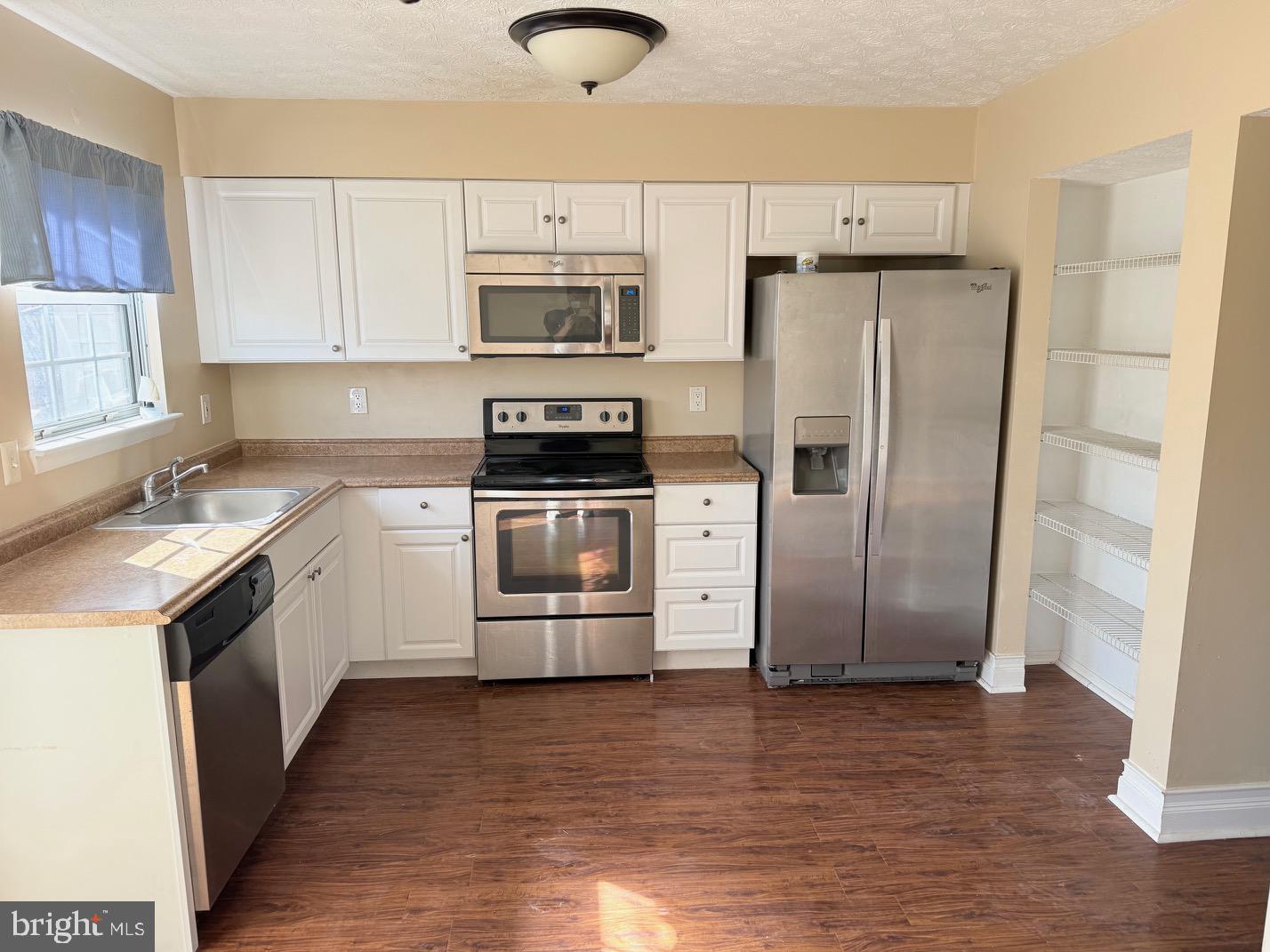 a kitchen with white cabinets and stainless steel appliances