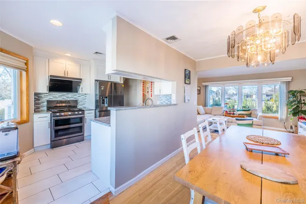 a large kitchen with a table chairs refrigerator and a stove top oven