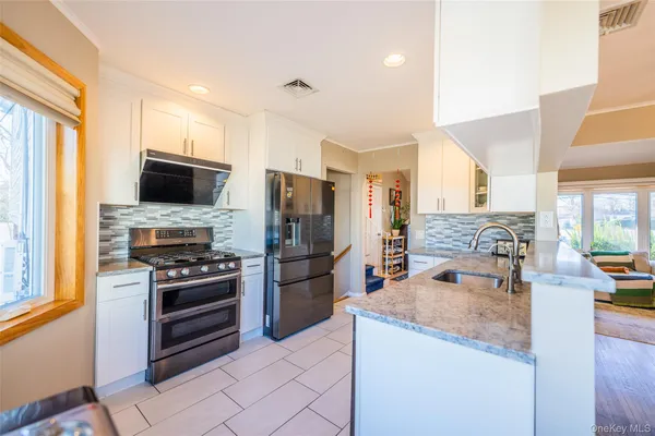 a kitchen with granite countertop a refrigerator and a stove top oven