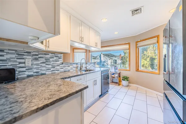a kitchen with stainless steel appliances granite countertop a sink and a stove