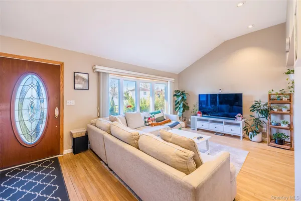 a living room with furniture a flat screen tv and a large window