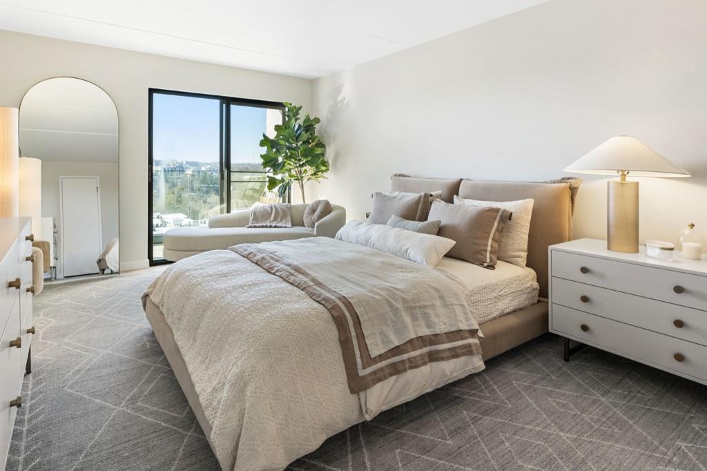 2460 Peachtree Road Northeast, Unit 514 Atlanta, GA 30305 - Photo 21 of 36 a bedroom with a bed and a chandelier