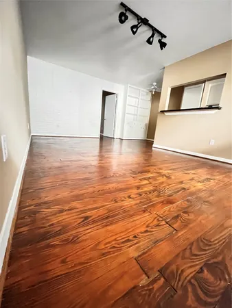a view of a room with wooden floor and white walls