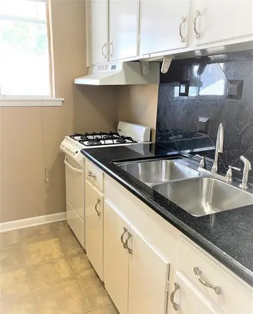 a kitchen with kitchen island a sink stove and cabinets