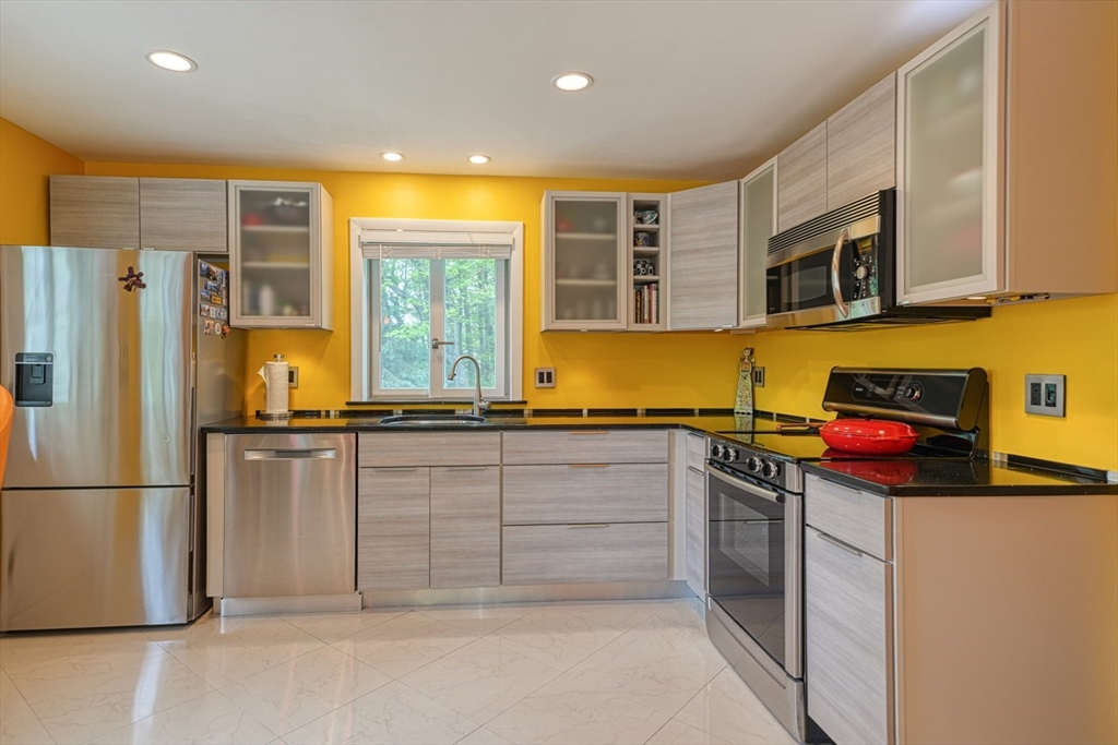 27 Wheeler Road Westborough, MA 01581 - Photo 14 of 41 a kitchen with stainless steel appliances granite countertop a stove and a refrigerator
