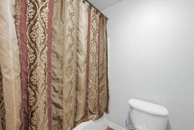 a white toilet sitting next to a shower curtain