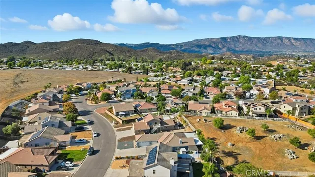 an aerial view of residential houses with outdoor space and trees