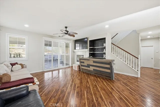 a view of a livingroom with furniture hardwood floor and windows