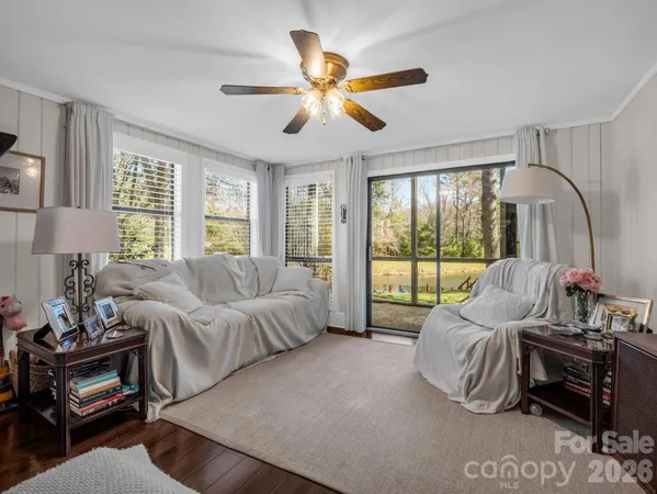 a view of a room with wooden floor and a floor to ceiling window