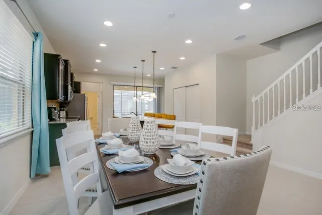 a dining room with furniture a large window and kitchen view