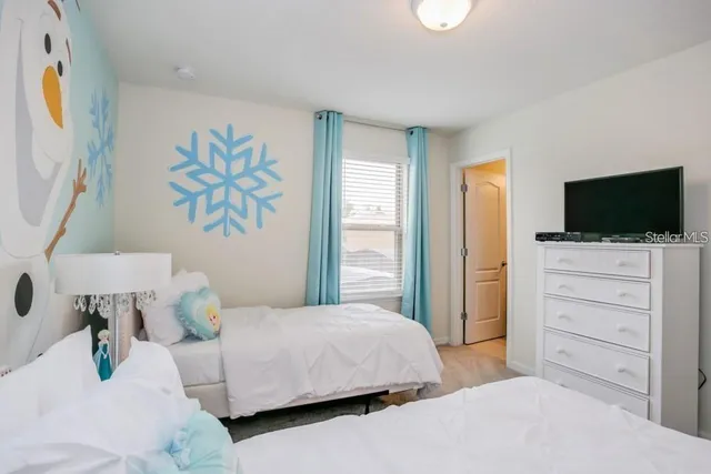 a bedroom with a bed and a flat screen tv